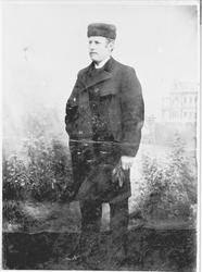 Studioportrett i helfigur av Bernhard Killi, iført pelslue.