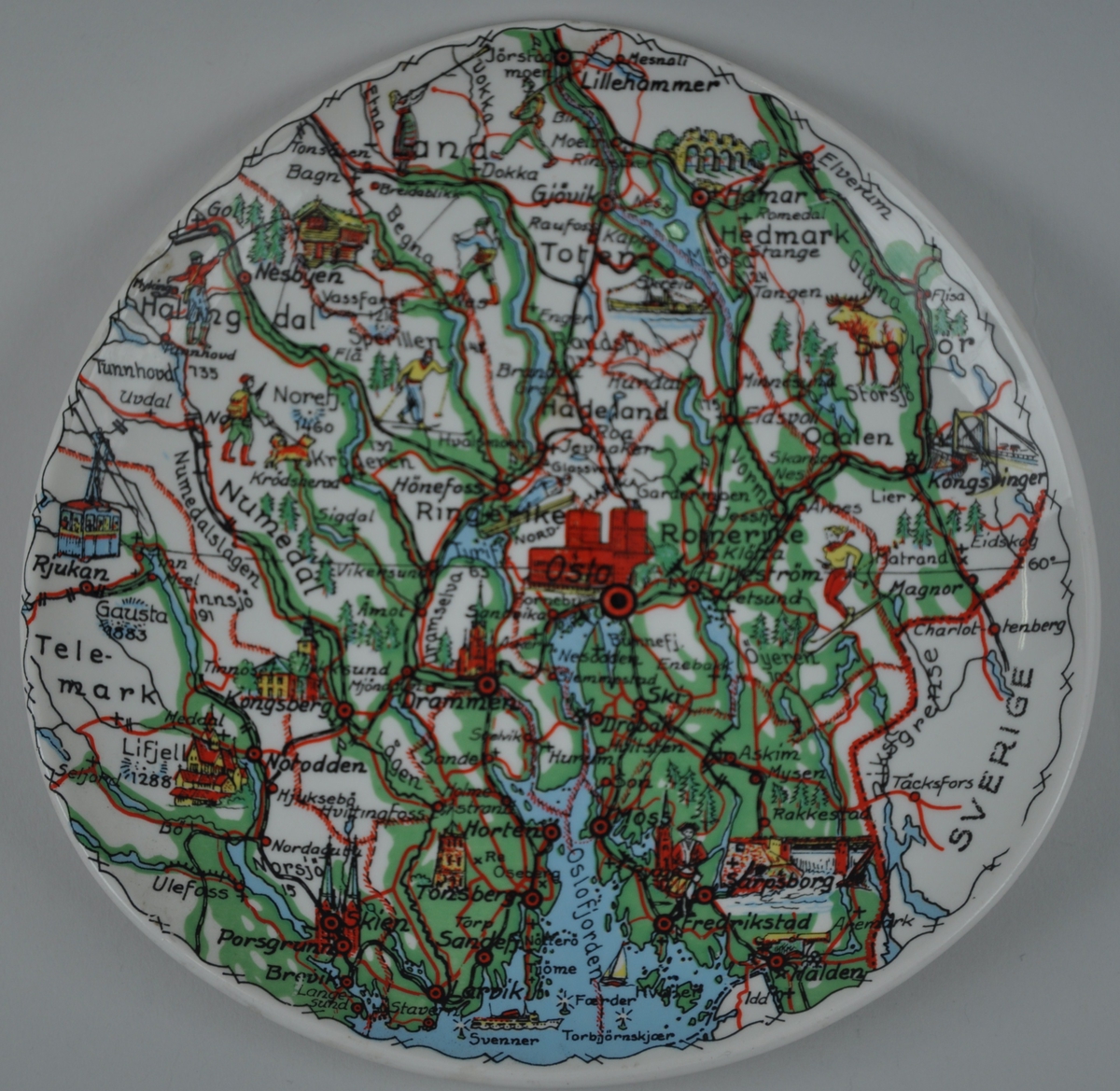 Motivet er eit kartutsnitt som viser Oslo i midten og områda rundt frå Larvik og Halden i sør til Lillehammer i nord, frå Rjukan i vest til Kongsvinger i aust.
