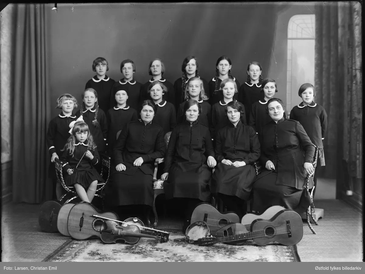 Frelsesarmeen, musikkforening, gruppe med kvinner og jenter
fotoatelier. 
Påskrift negativ: 
Eske merket: Grupper 1929.