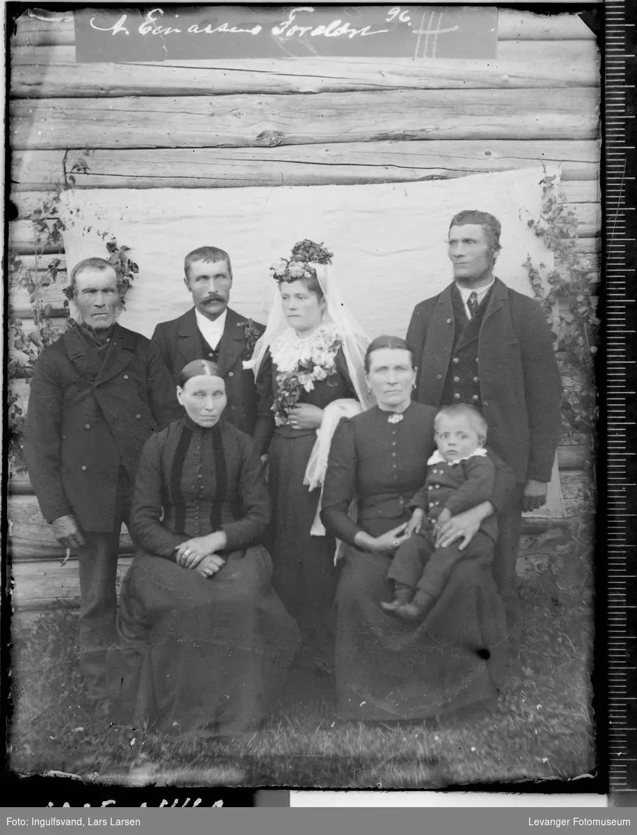 Gruppebilde av et brudepar, to menn, to kvinner og et barn.