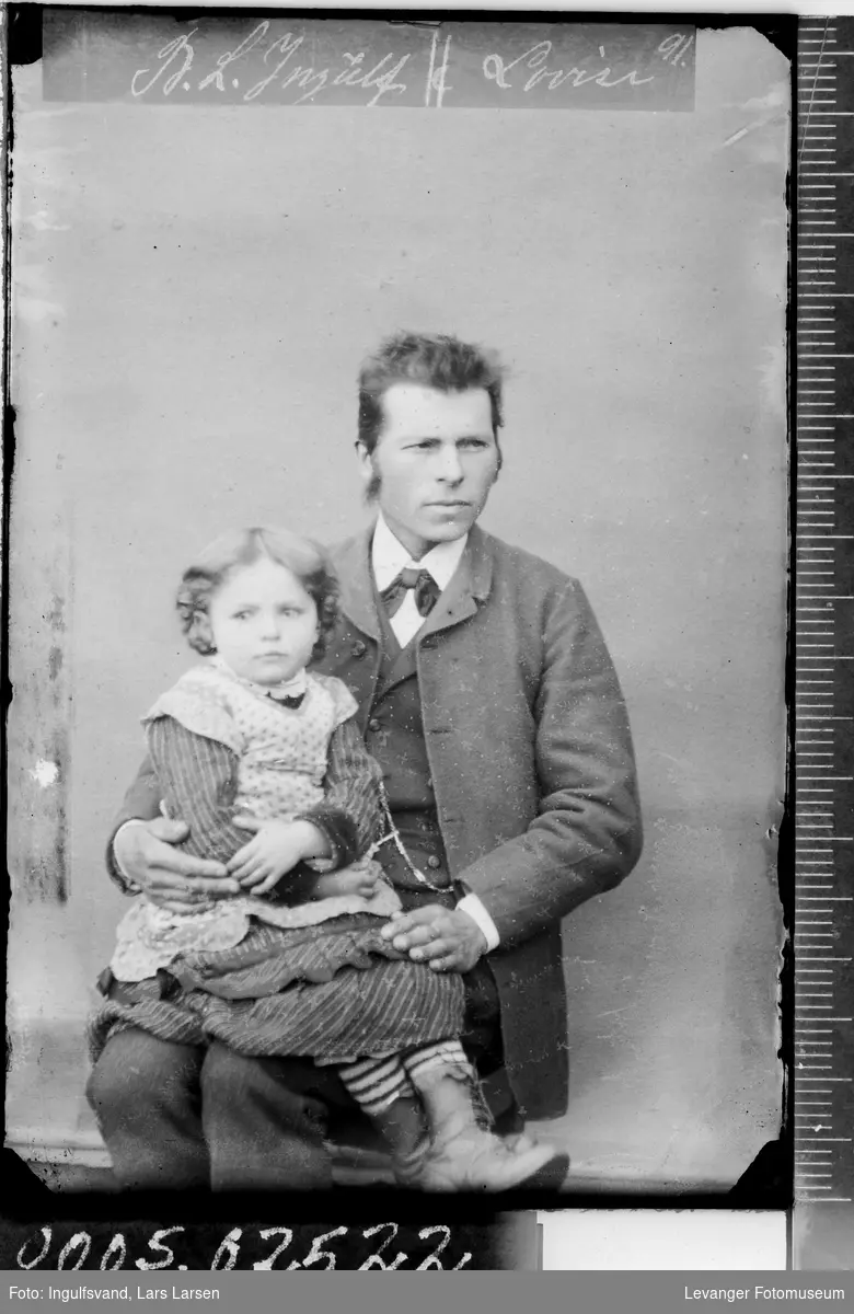 Portrett av sittende mann med et barn på fanget.