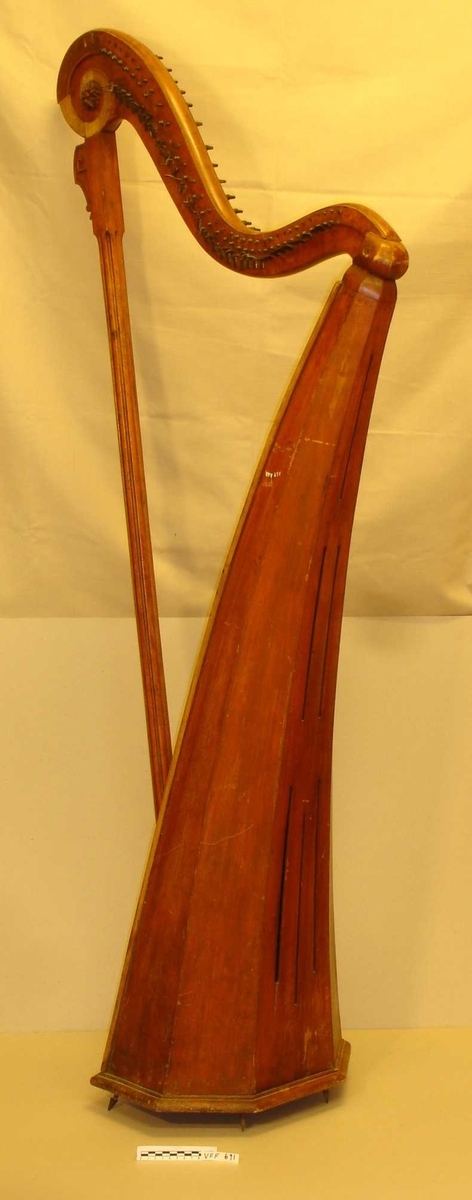 Sekskantet lydkasse som buer litt utover.  Lydkassen av gran, resten av harpen av bjørk. Fernissert.