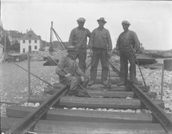 Kaianlegget - jernbanesporet legges på kaia - fire arbeidere