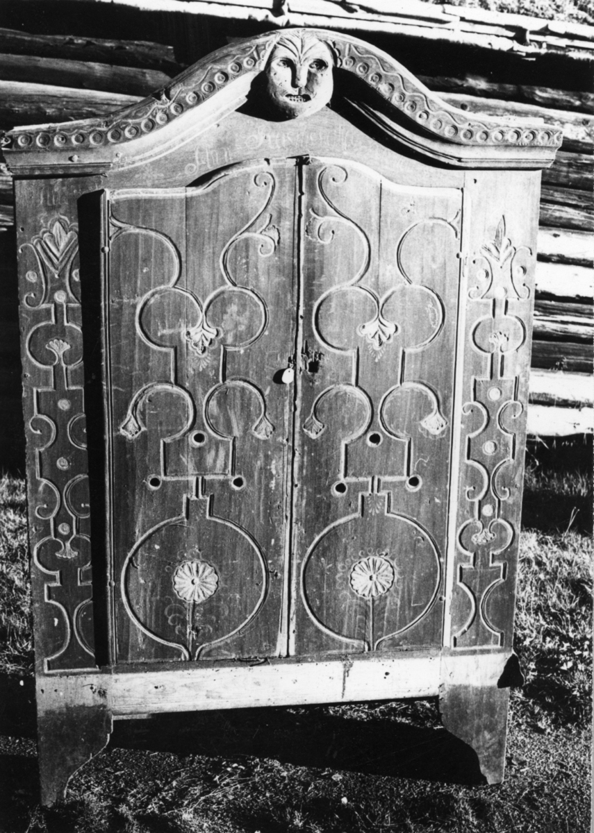 På dørene og på sidene av dem er innskåret runde og knekkede barok-bånd og småblader m.m.