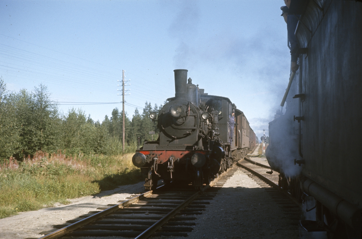 Kryssing mellom to godstog på Arneberg stasjon på Solørbanen. Damplokomotiv type 27a