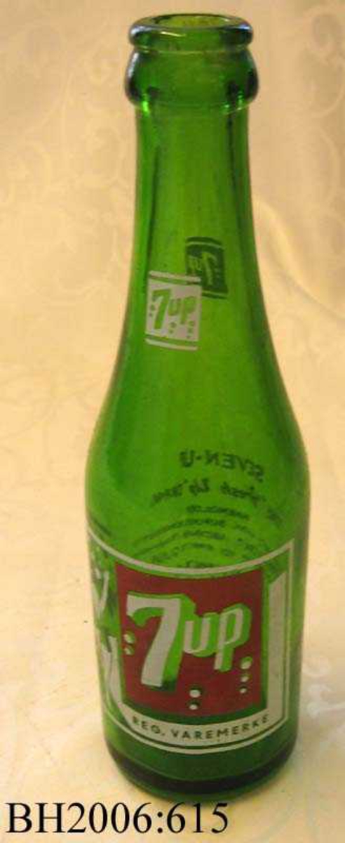 Brusflaske av grønt glass med etikett trykket på flaskens front.