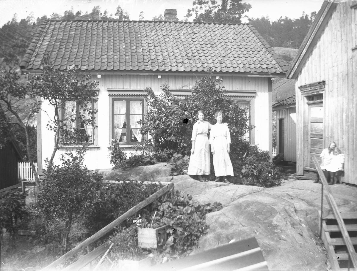 Kvinner og barn utenfor hus - kanskje i Kragerø