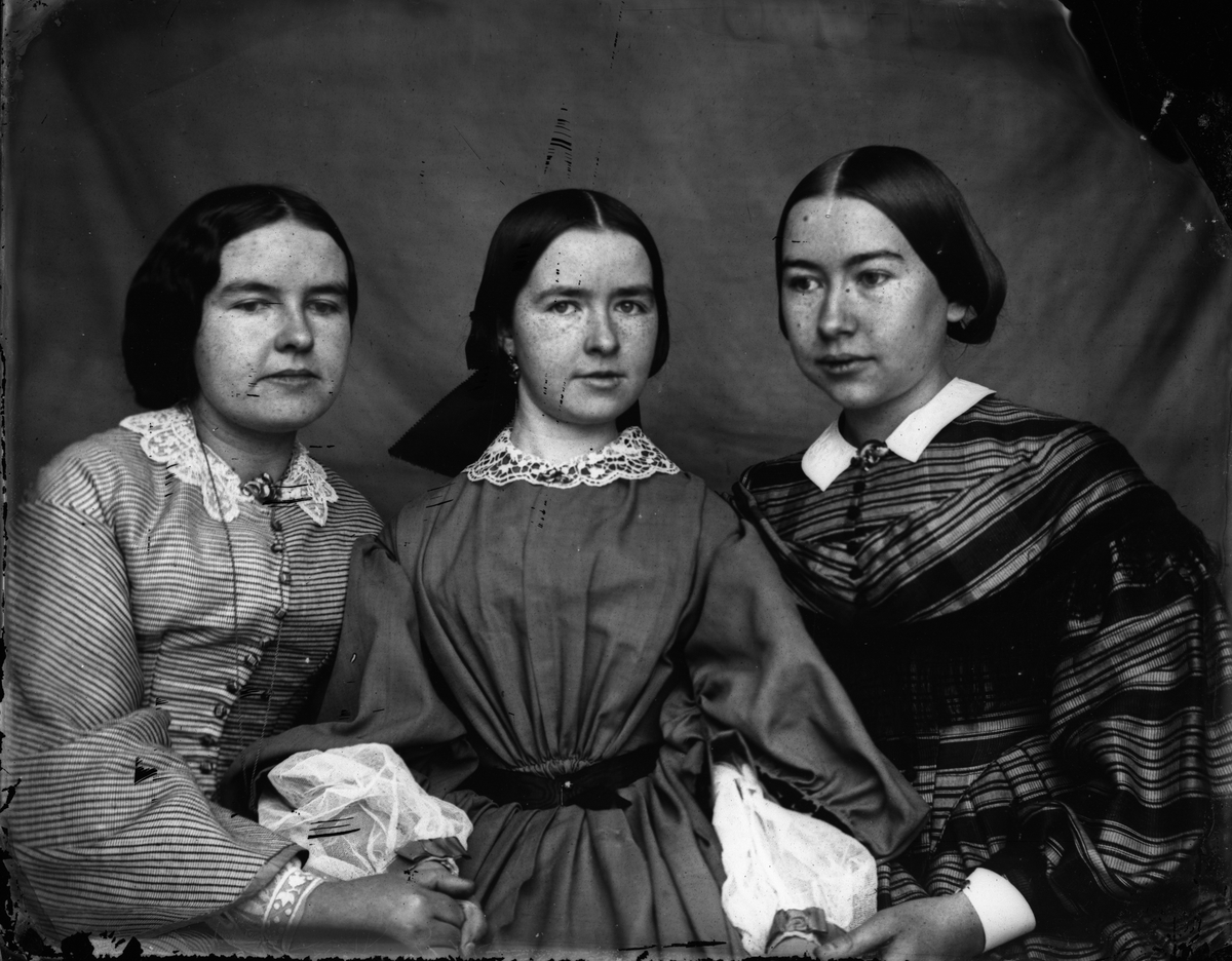 Tre unge kvinner sittende