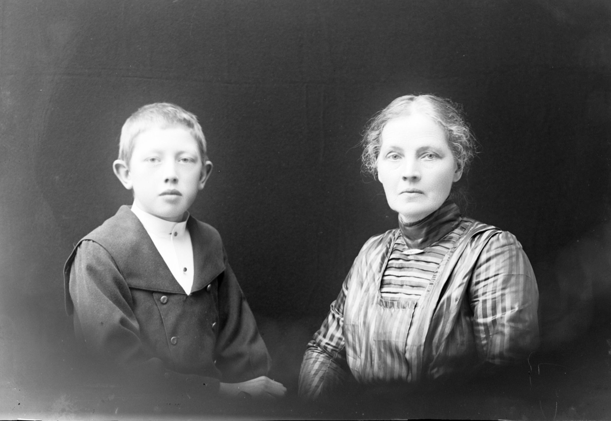 Studioportrett av en gutt og en kvinne i halvfigur.