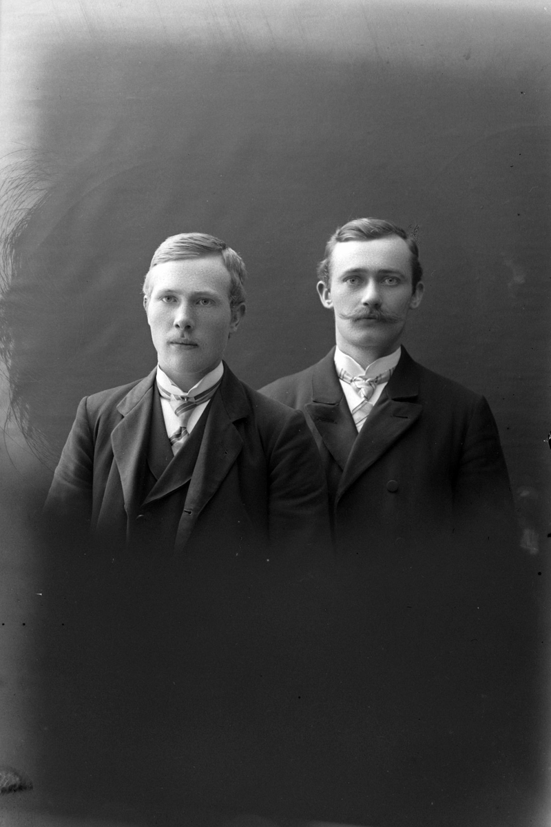 Studioportrett av to menn i halvfigur.