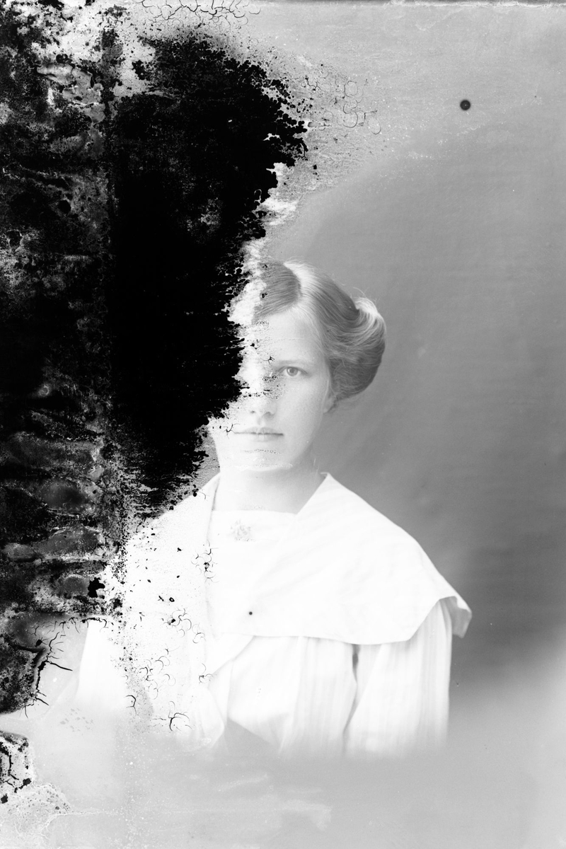 Studioportrett av ung kvinne i halvfigur.