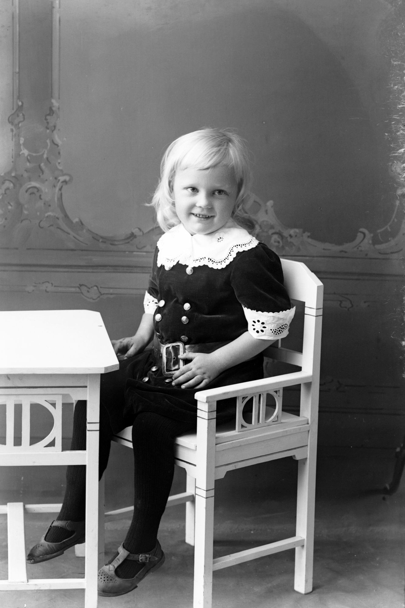 Studioportrett av en ung pike sittende på en stol.