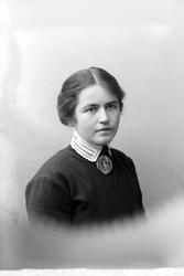 Studioportrett i halvfigur av Helga Elisabeth Daae.