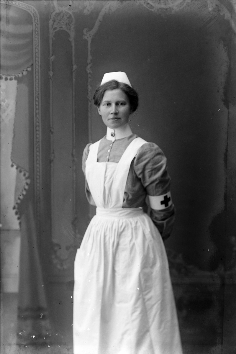 Studioportrett av en sykesøster i uniform.