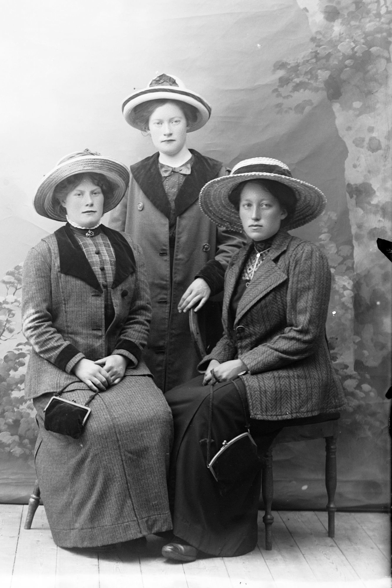Studioportrett av tre kvinner i helfigur.