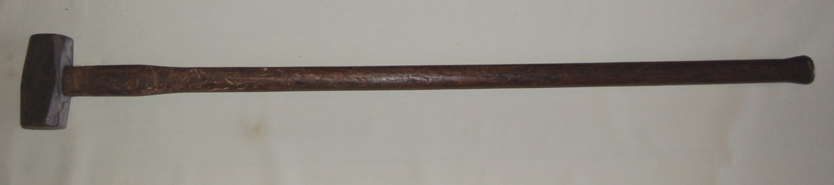 Sleggehammeren er av stål, og festet til et forholdsvis langt skaft av tre.