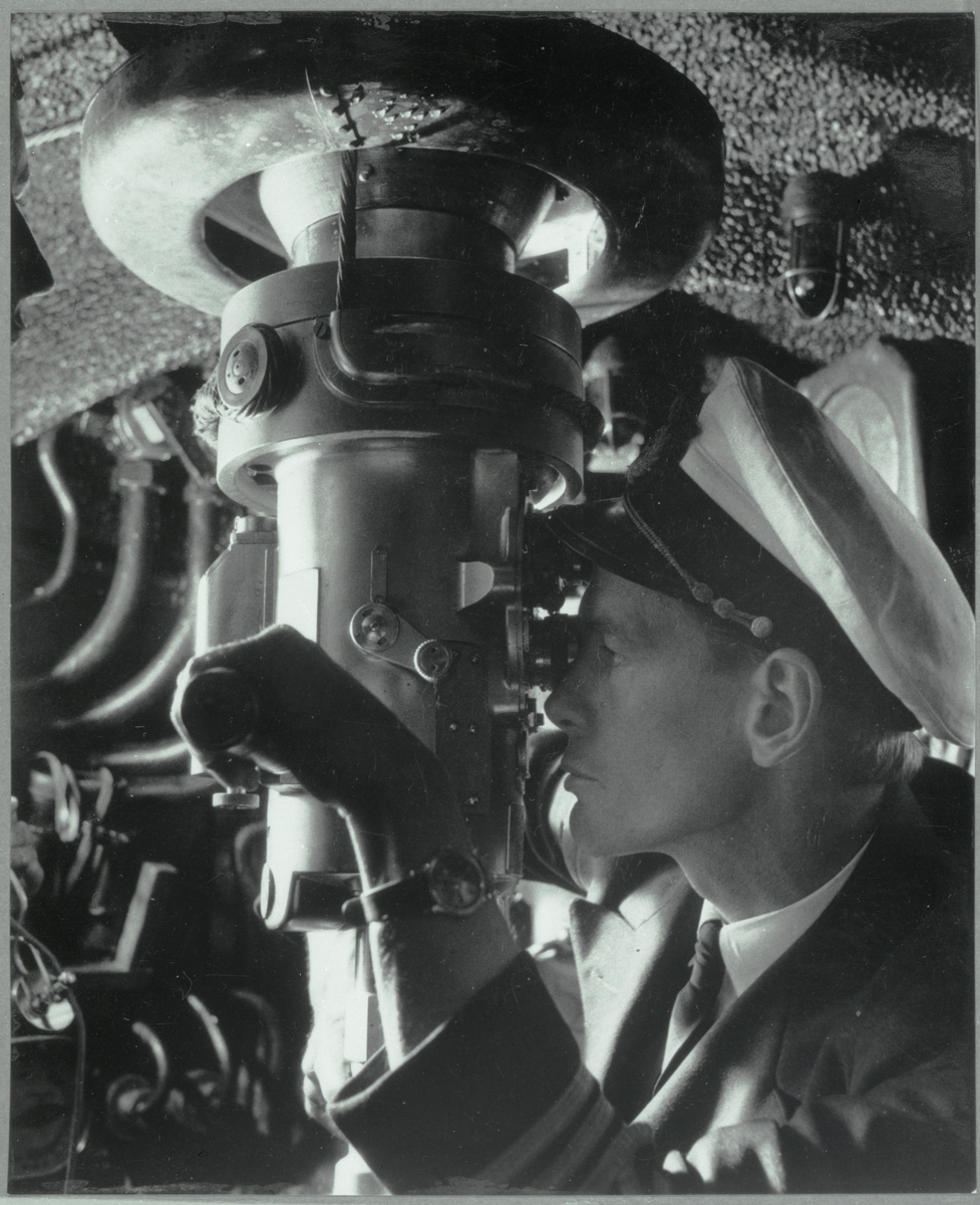Kapten Wessel tittar genom periskopet ombord på ubåten TUMLAREN.