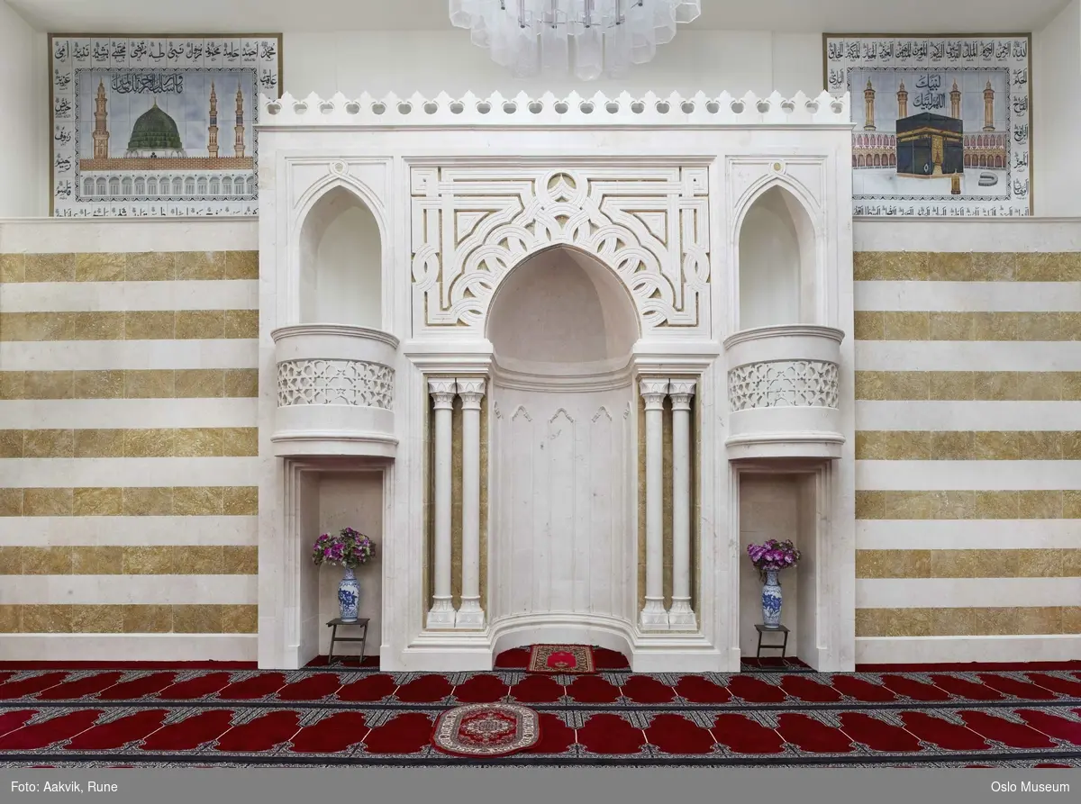 Islam, interiør og symboler fra moskeen Central Jamaat-e Ahl-e Sunnat Norway, Medina, Mekka, koranen, bønn, klokke, lysekrone, qibla, søyler, veggdekorasjon, buer.