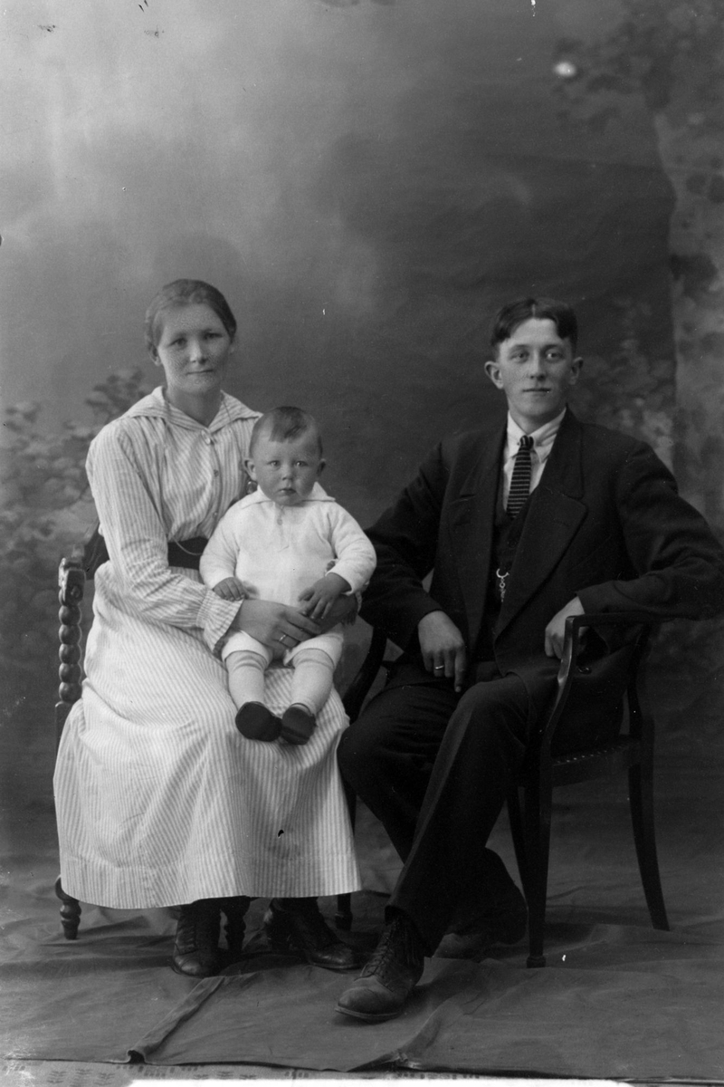 Studioportrett av en mann og kvinne med et barn.