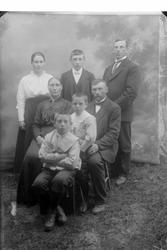 Studioportrett av syv personer i helfigur.