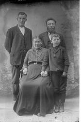 Studioportrett av fire personer i helfigur.