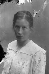 Studioportrett i halvfigur av en kvinne.