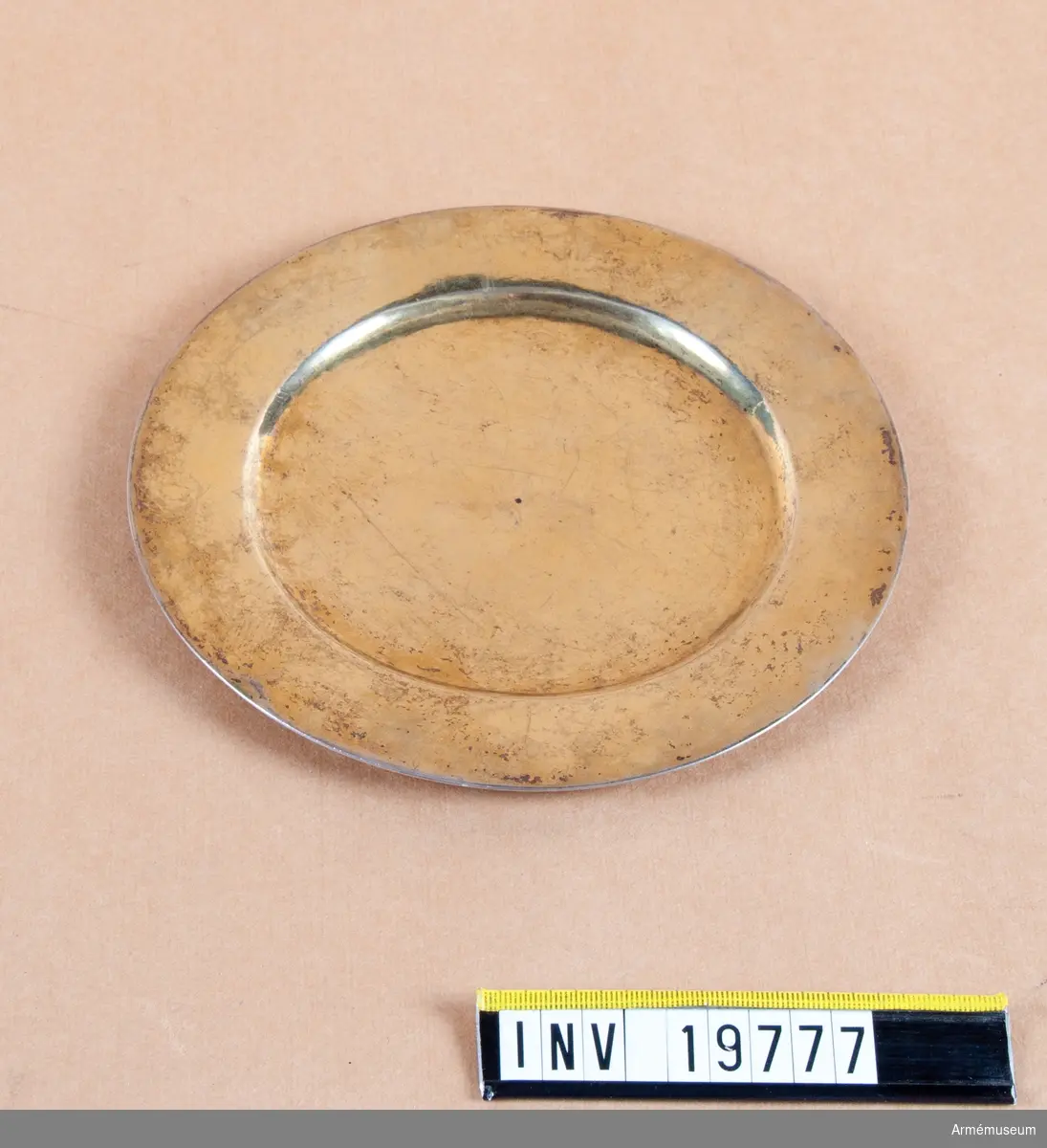 Förgylld paten. På undersidan märkt med åldermannaranka, dvs. paten tillverkad före 1754. H-årsbokstaven 1696, No 2 och 14 3/4 (kan vara lod) och år 1766. I mitten en svart hålihget 1x1 diameter, två avtryck av pung på undersidan. 