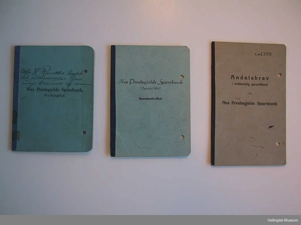 Tre bøker i tilknytning til Otto K. Rømckes legat til utdannelse for unge kvinner og menn: Bankbok, Sparebankvilkår og Andelsbrev. Hullet med hullemaskin på høyre side. 
(Om bilderekken - se referanser)