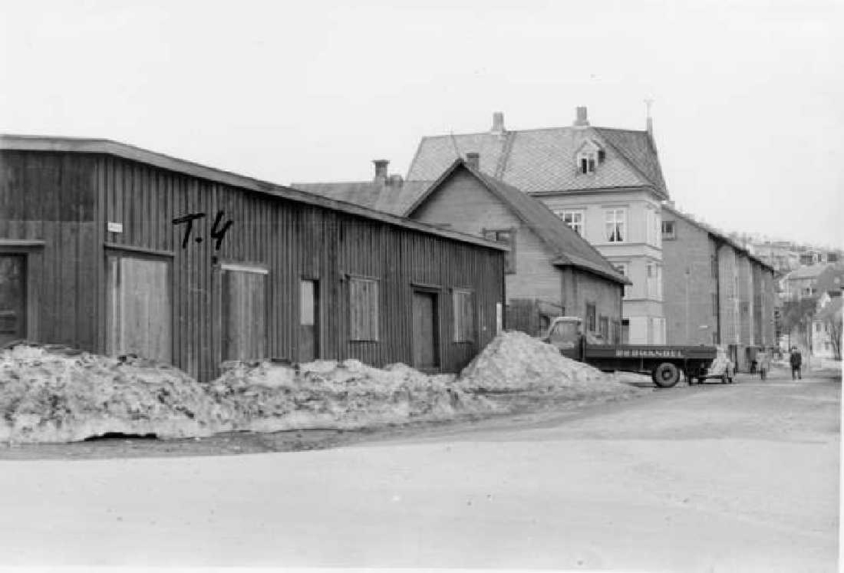 Frydenlund Kv. 34  T.4. T.4 er brakkene på "Smitimta". Kontor og lager. Lastebil. Bygningen bak bilen er Rønning`s Hestestall og deretter Rønning-gådrden. Helt bak er Murerbyggene i Myrveien.