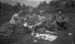 Kaffe og kaker ute på jordet. Aagot Olausssen holder koppen.