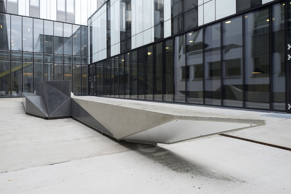 På uteplassen mellom bygningene har Anders Sletvold Moe skapt verket "Folded Shape Drifter / Unfolded Shape Drifter", som består av en fjorten meter lang betongskulptur og et veggmaleri utført på en av fasadene som vender ut mot plassen. Skulpturens langstrakte og geometriske former understreker gårdsrommets langstrakte form, og skulpturen fungerer også som sitteplass for studenter og ansatte. Veggmaleriet har et abstrakt uttrykk, og er satt sammen av samtlige av skulpturens flater, som et todimensjonalt puslespill. I farge og komposisjon henspiller veggmaleriet på uttrykket i arkitekturen i de eldre bygningene, som er fra 1950-tallet, og knytter an til NHHs historie. Skulpturen er mer futuristisk i sin framtoning, og peker framover mot høyskolens fremtid.