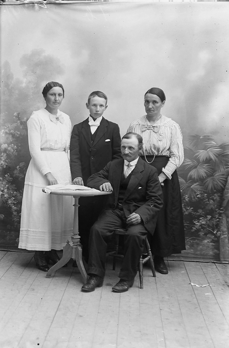 Familieportrett, sannsynligvis besteforeldre, datter og dattersønn. Konfirmant. Gildeskål. 1918.