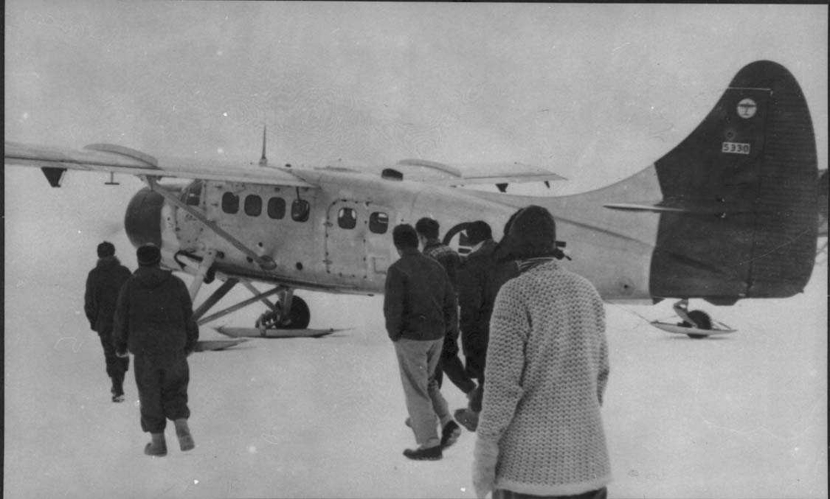 Ett fly på isen, Otter OAF. Mange personer ved flyet.