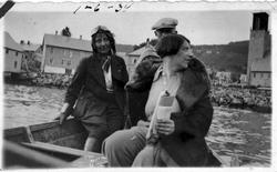 Tre personer i en liten båt. To kvinner foran og en eldre ma