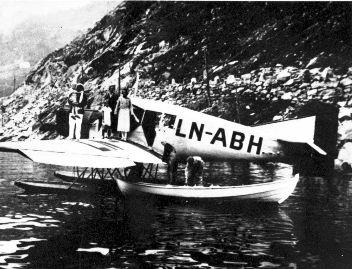 Ett fly, Junkers F.13W. I 1932 omregistrert LN - ABH og solgt til Nord -Norges Aero A/S, Narvik. Det er fem personer på vingen av flyet og to personer foran i en robåt. Det er også to personer på en større båt, som er i bakgrunnen av flyet.  