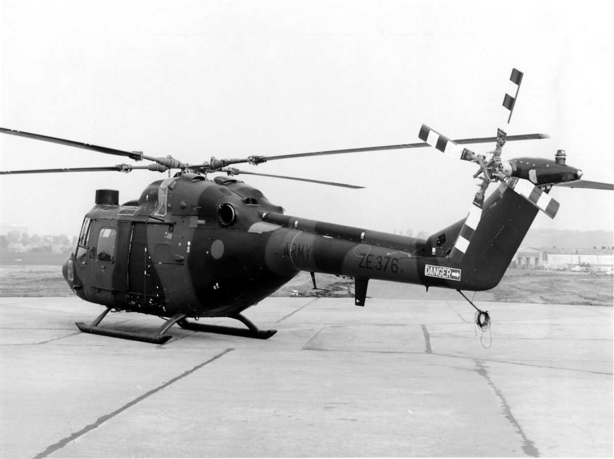 Ett helikopter på bakken. Westland Lynx AH Mk.7 tilhørende British Army, merket ZE376. Bygninger ses i bakgrunn t.h og t.v.