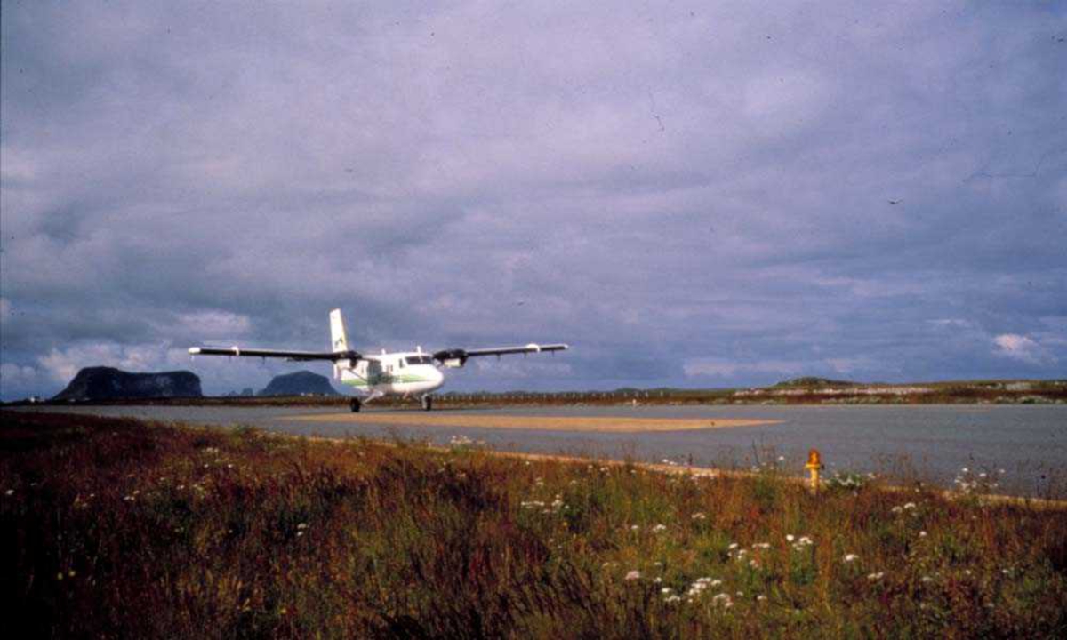 Lufhavn. Ett fly, LN-BNH, DHC-6-300 Twin Otter fra Widerøe lander på Røst.