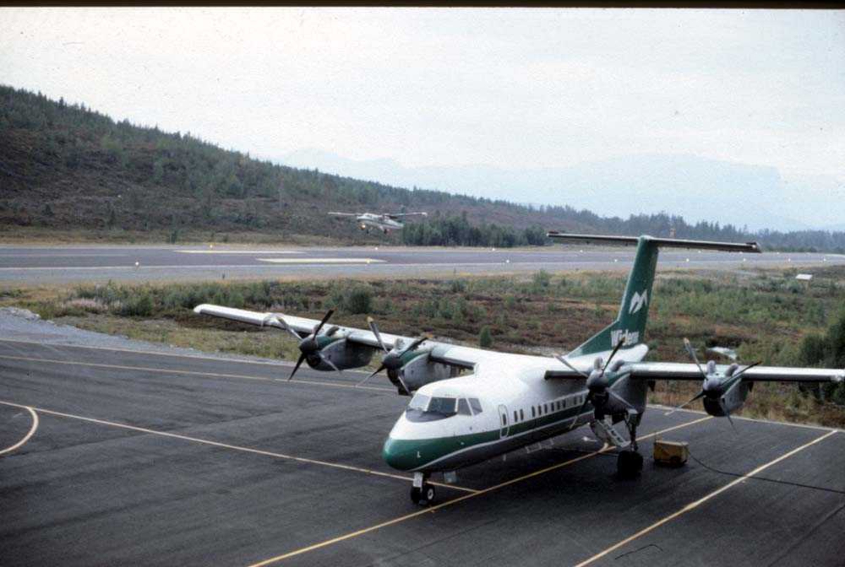 Lufthavn/flyplass. Sandane. Ett fly, LN-WFL, De Havilland Canada DHC-7-102 Dash7 fra Widerøe, parkert. Ett fly, DHC-6-300 Twin Otter fra Widerøe, take off. 