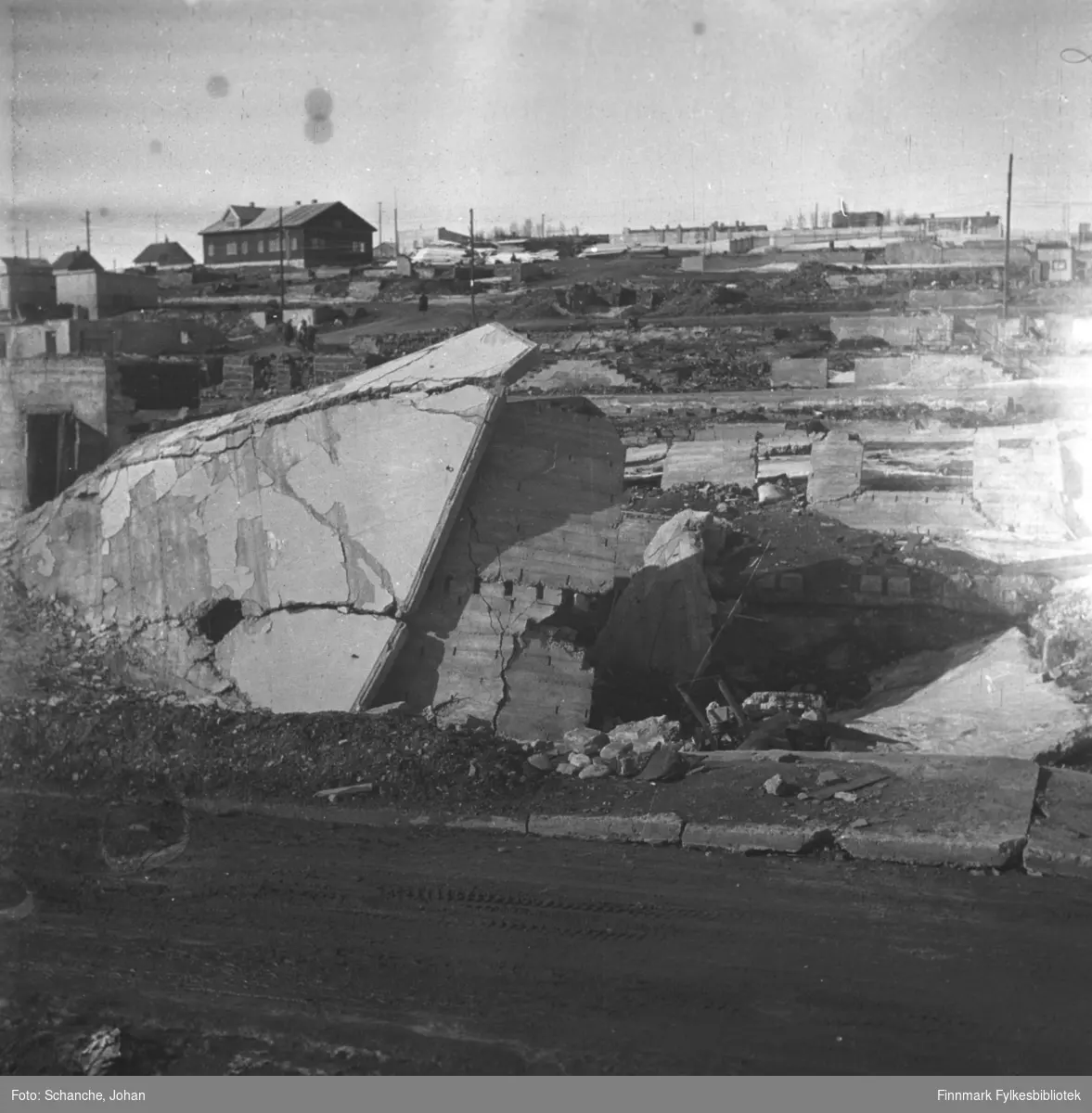 Ruiner i  sentrum av byen i 1946. Bak ruinene noen byggninger og brakkebyen.