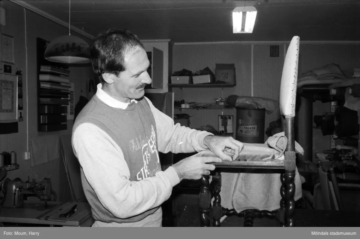 Lindome Tapetserarverkstad vid Spårhagavägen i Lindome, år 1985. "Lars Fagerberg i färd med att klä om en stol."

För mer information om bilden se under tilläggsinformation.