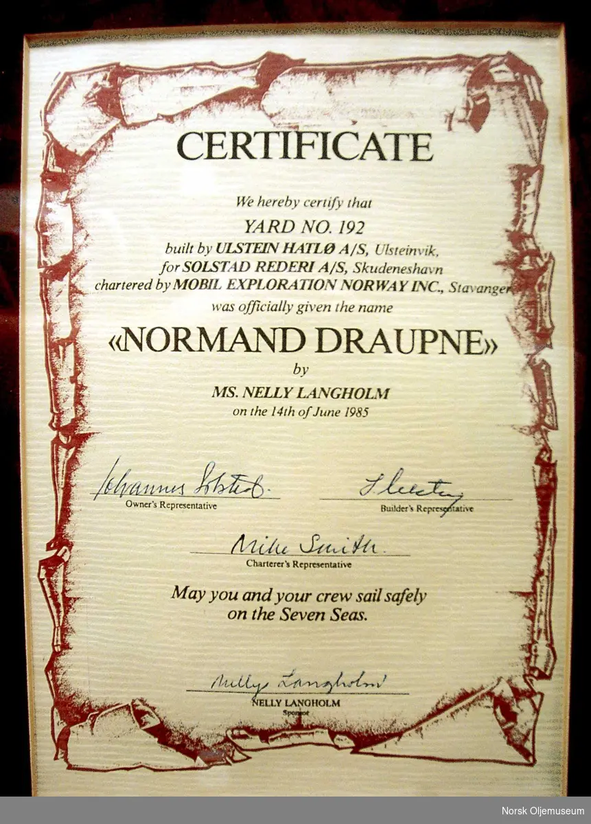 Innrammet sertifikat fra dåpen til beredskapsfartøyet Normand Draupne. Sertifikatet er signert av representanter for rederiet, verftet og befrakteren, samt skipets sponsor/gudmor. På baksiden er rammen er signert av 149 andre. Disse var trolig tilstede ved dåpen.