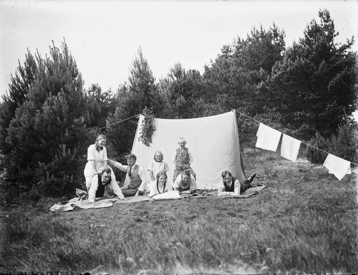 Åtta personer vid ett tält.