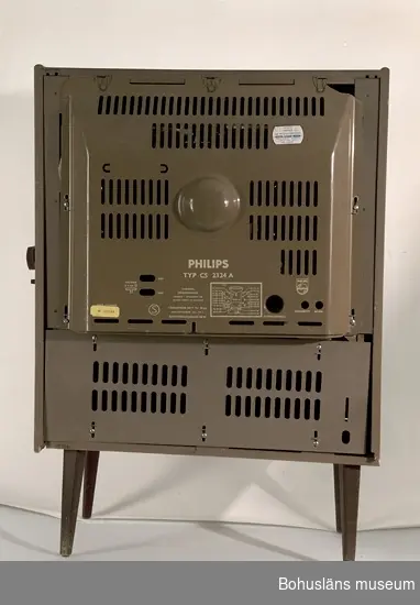 21-tums TV inbyggd i teakskåp med skjutdörrar dvs. dubbla jalusiedörrar som dras för rutan från sidorna när apparaten inte används.
Sladd med stickkontakt avklippt.
Apparaten var utställd i gamla basutställningen, 1960-talet.