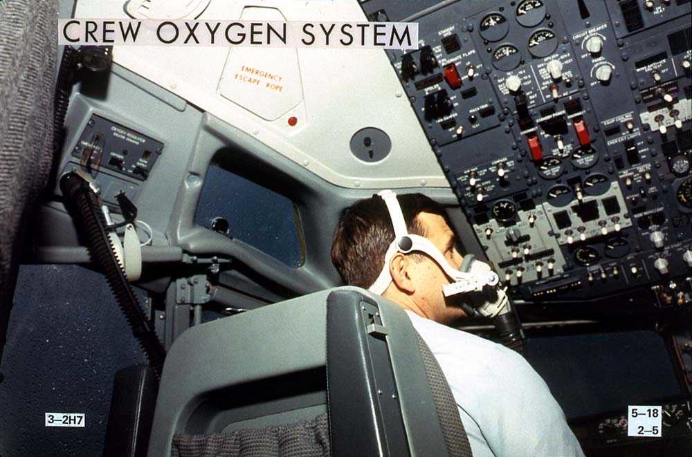 En person som sitter i cockpiten på en Boeing 737-200 med en oksygenmaske på seg.