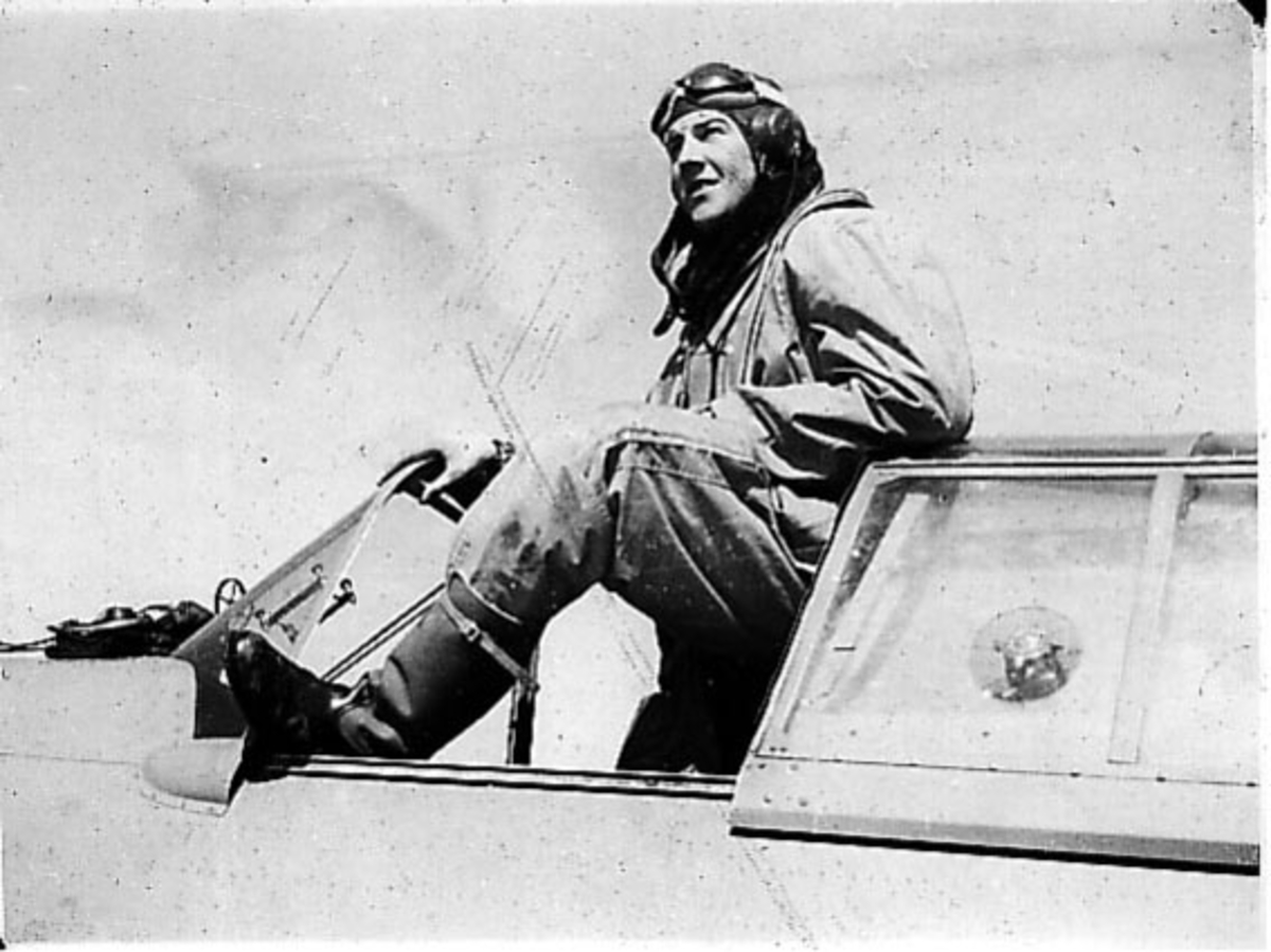 Portrett, en person, flyger, lener seg ut av cockpiten på et fly.