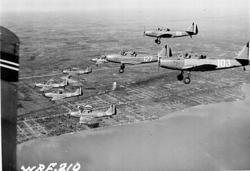 Luftfoto. 8 fly i formasjon Fairchild M-62A, bl.a. 101, 127,