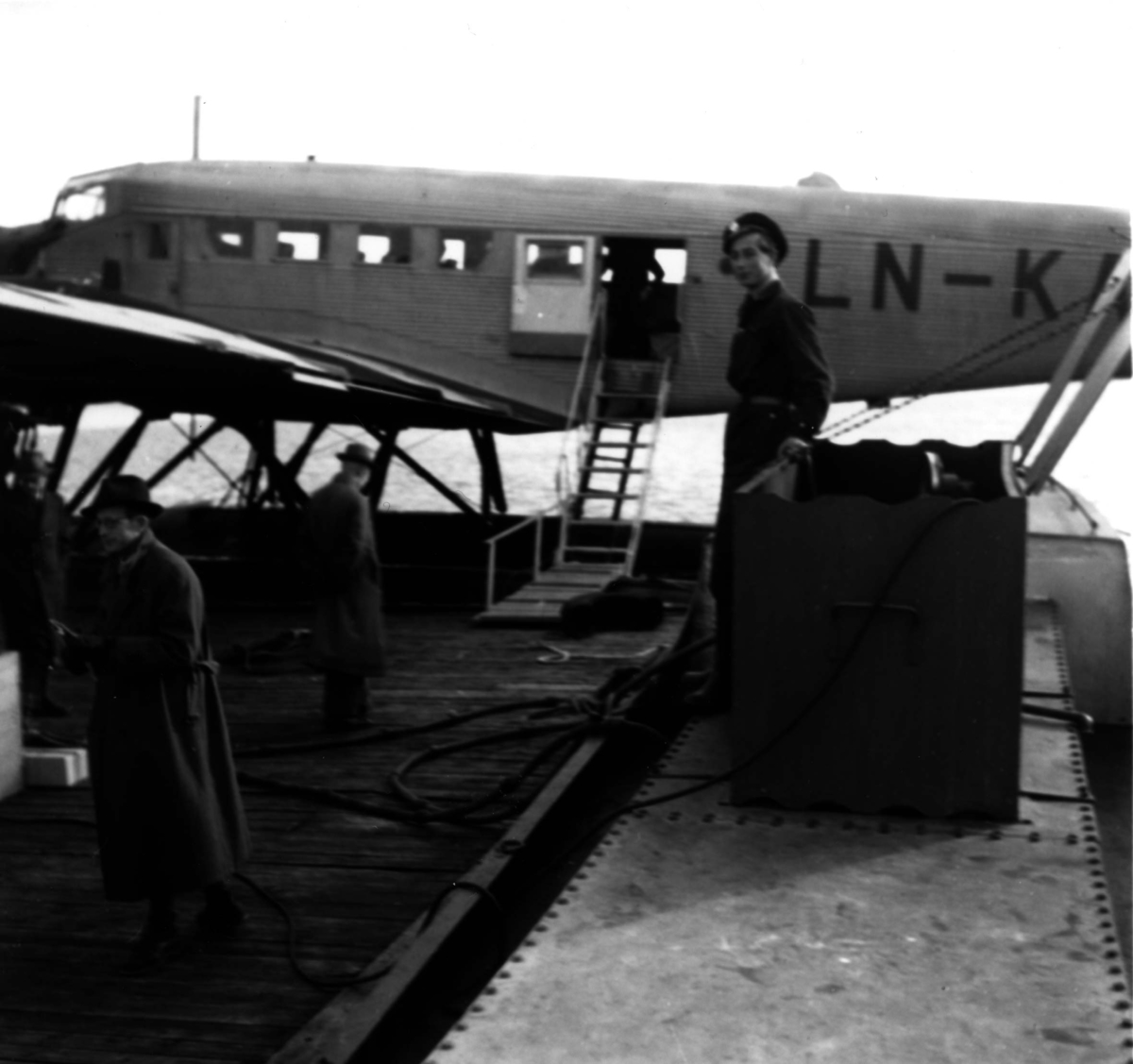 Sjøflyhavn, Ett fly ligger ved kai, Junkers Ju52 3/mg LN-KAF "Askeladden" fra DNL. Flere personer på kaia.