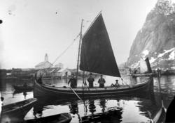 Havneområde med flere nordlandsbåter. Kirkebygningen i bakgr