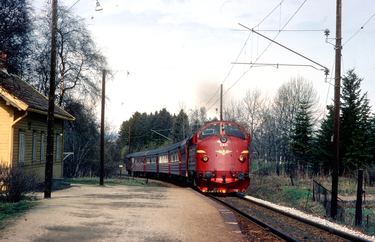 Rørosbanens dagtog, tog 302, passerer Stavne holdeplass i Trondheim. NSB dieselelektrisk lokomotiv Di 3 611 trekker toget.