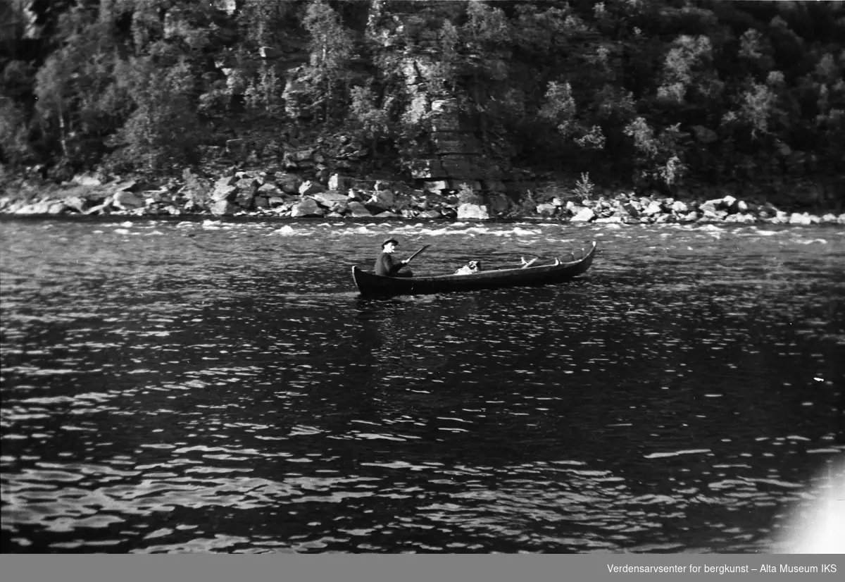En mann sitter i elvebåten midt på elva.
Bildet er tatt i fiskesesongen på sommeren i 1949.